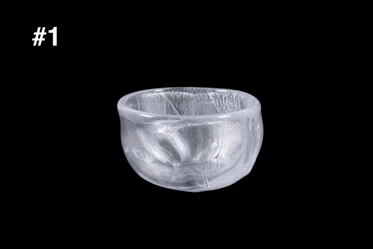 Handmade silver toned glass guinomi sake cup with a frosted textured surface and rounded rim against a black background