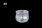 Handmade clear silver toned guinomi cup with a rippled textured surface and softly rounded rim against a black background