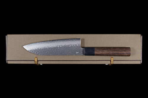 Gen 150mm Kurouchi Santoku, right side of the blade with maker's mark, lying on its box, viewed from above