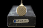 End of the octagonal wooden handle on the Gesshin Uraku 120mm White #2 Deba, resting on its box