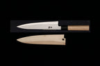 Gesshin Ginga 210mm carbon wa gyuto by Ashi Hamono with polished blade and ho wood handle displayed above its wooden saya on a black background